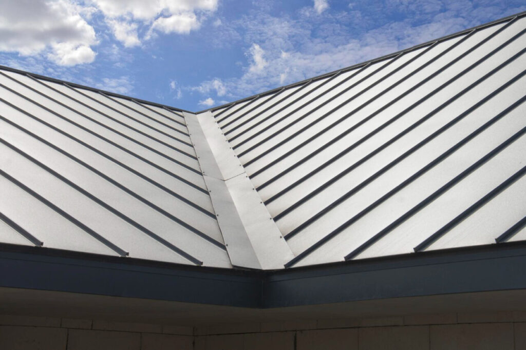 Maison contemporaine dotée d'une toiture métallique nervurée, illustrant la modernité, la durabilité et l'efficacité énergétique dans l'habitat résidentiel.